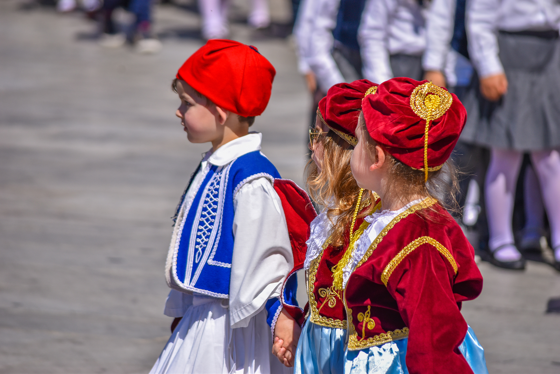 Young Greek kids wearing traditional costumes during a parade